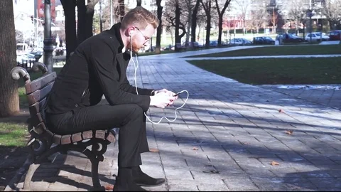Sad businessman alone in park checking social media Video stock 84835533