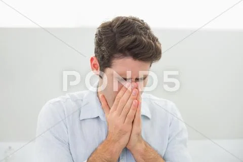 Sad casual young man with hands to his face Stock Photos