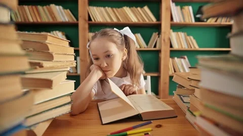 Sad Caucasian girl in library having some difficulties during homework from book Video stock 195013853