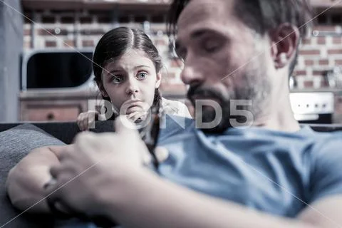 Sad cheerless girl looking at her drunken father Stock Photos