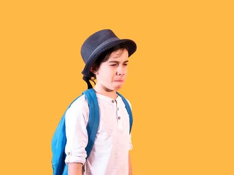 Sad Child with Backpack on Orange Background Stock Photos