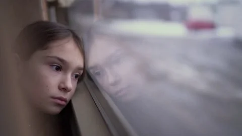 Sad child in the bus looking out the window in evening time Видео 71898256