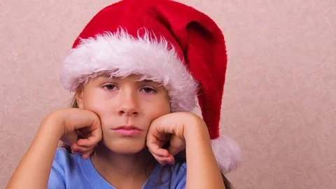 Sad child in a Christmas hat. Stock Footage