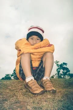 Sad child on nature background. Problem families concept. Retro style. Stock Photos