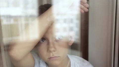Sad child is watching the window Stock Footage 172391174