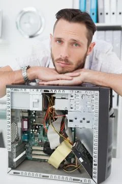 Sad computer engineer leaning on computer Stock Photos