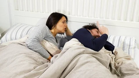 Sad couple fighting lying in bed man ignoring wife closeup Stock Footage 87765657