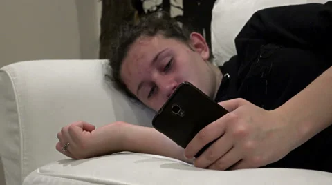 Sad crying girl using Smartphone app on phone despared, lying at sofa 스톡 동영상 63461798