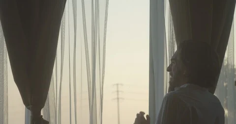 Sad crying man having an intense conversation on phone next to window at dusk 2 库存影片 128516472