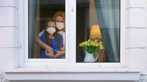 Sad daughter looking through the window expecting to be huged 스톡 동영상 126989182