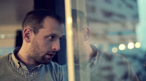 Sad, depressed man drinking tea by the window at home HD Stock Footage 21881553