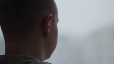 Sad depressed man drinking tea by the window in home Stock Footage 70898686