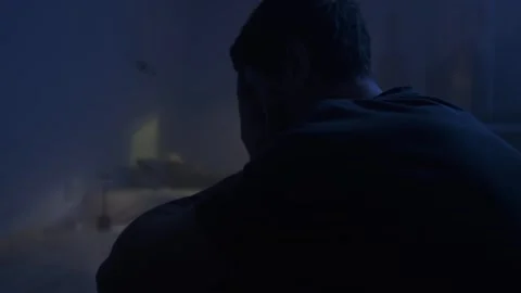 Sad depressed man sitting alone in dark bedroom, emotional burnout, hopeless Stock Footage 320543491