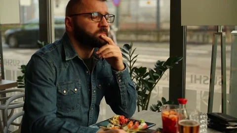 Sad, depressed young man looking to camera in restaurant 스톡 동영상 71000088