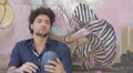 Sad, depressed young man sitting near a graffiti wall HD Footage