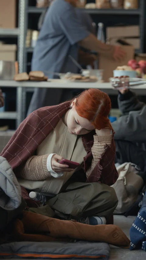Sad Displaced Woman Using Smartphone in Humanitarian Aid Shelter Stock Footage 339072407