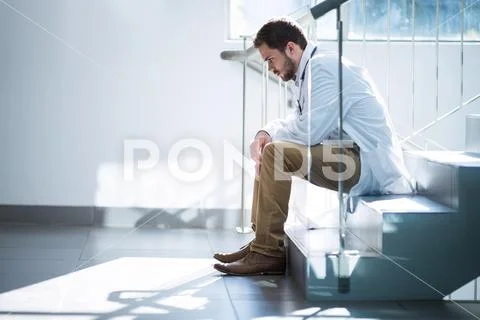 Sad Doctor Sitting On Staircase