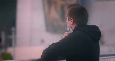Sad Dramatic young boy on the bridge taking of medical mask during Stock Footage 144935173