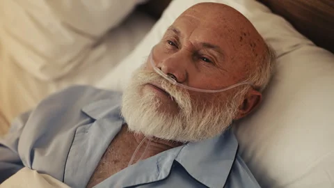 Sad elderly man with nasal cannula in hospital bed, isolated in old age Stock Footage 310009086