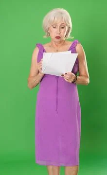 Sad elderly woman with documents in front of green screen Stock-Fotos