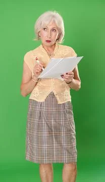 Sad elderly woman with documents in front of green screen Stock-Fotos