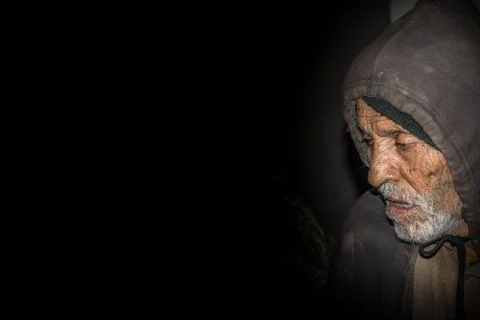 Sad expression of an elderly sick man in a dark room Stock Photos