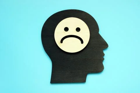 Sad face on the head shape. Negative thinking and depression. Stock Photos