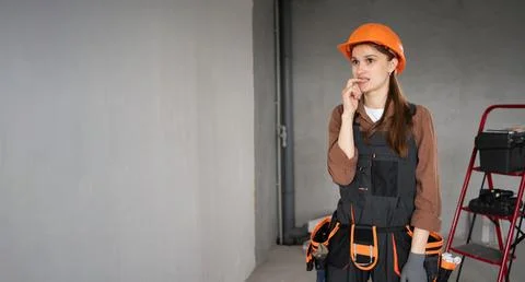 Sad female builder biting nails for thinking of stress or crisis. Tired ner.. Stock Photos
