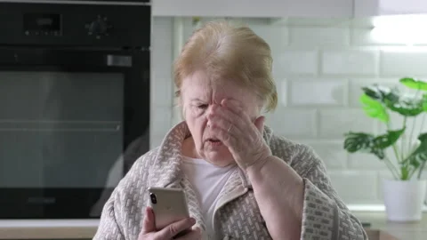 Sad frustrated 70 years elderly woman at home looking at phone seeing bad news Stock-Footage 175027468