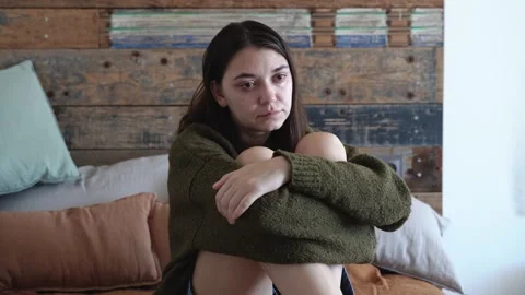 Sad frustrated young woman, sitting alone on the bed and crying Stock Footage 166166300