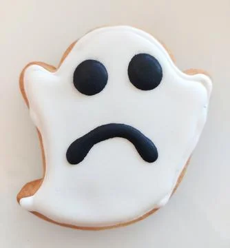 Sad ghost cookie decorated with icing for Halloween party Stock Photos
