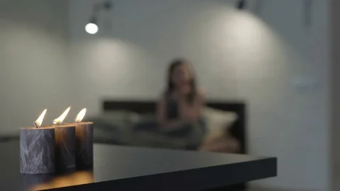 Sad girl on the bed by candlelight Stock Footage 81323402