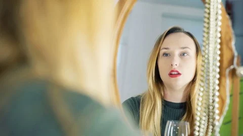 Sad girl having problems and looking at the mirror while drinking wine Stock Footage 70399770