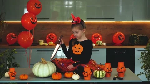 The sad girl with a knife doesn't want to cut the pumpkin in Halloween. Stock Footage