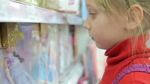 Sad girl looking at the dolls in the package Stock Footage 44752159
