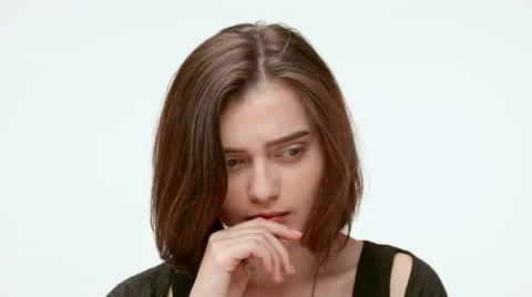 Sad grumpy girl on a white background. Close up. Slow motion Stock Footage 64121257