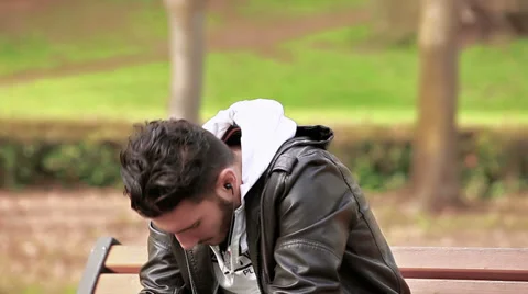 Sad guy at park with earphones | Stock Video | Pond5