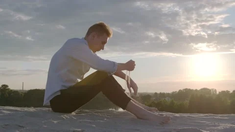Sad guy pouring sand through fingers. Concept male model. Emotions. Slow motion Stock Footage 135669122