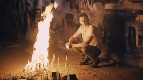 Sad guy warms by bonfire Video stock 91031265