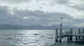 Sad landscape, rough water surface, stormy cloudscape over mountains on horizon HD Footage