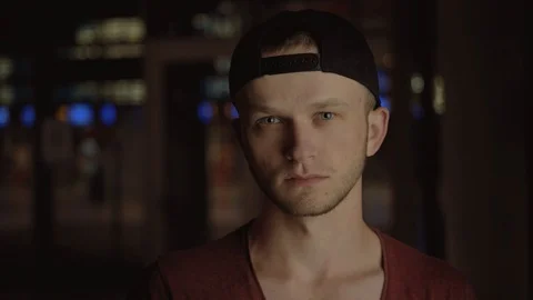 Sad likable guy in black cap looking at camera. Portrait of attractive Caucasian Stock Footage 91149762