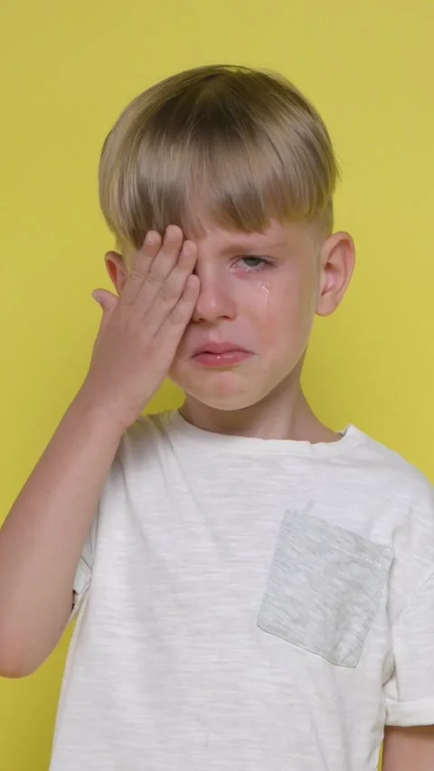 Sad little boy is crying on a yellow bac... | Stock Video | Pond5