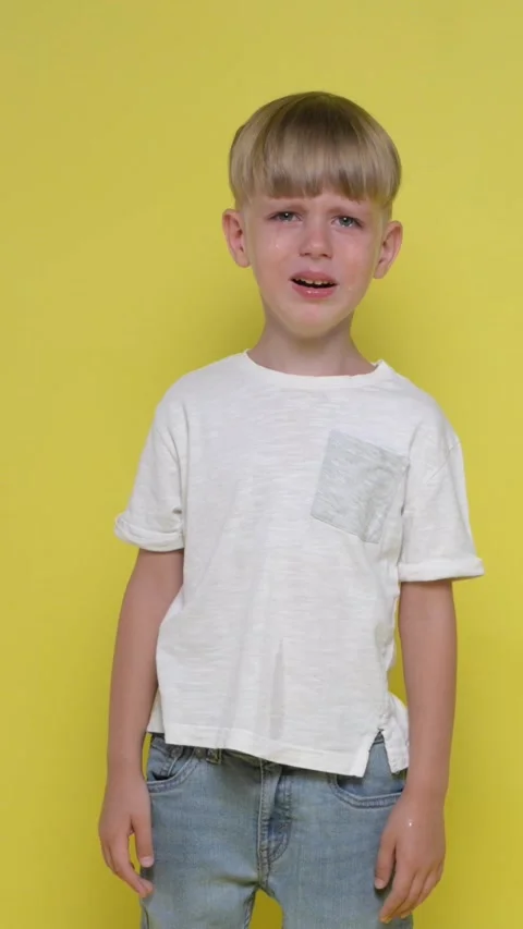 Sad little boy is crying on a yellow bac... | Stock Video | Pond5