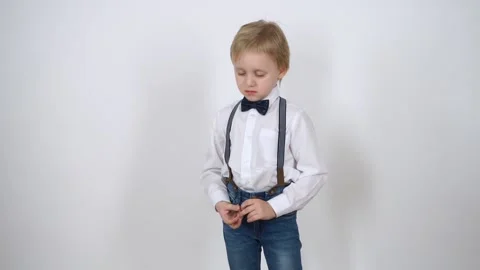Sad little boy on a white background. Dressed in jeans and a white shirt. Stock Footage 148053395