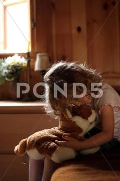 Sad little girl hugging teddy bear Stock Photos