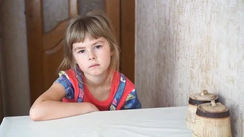 Sad little girl is sitting at the table. Stock Footage 129732853