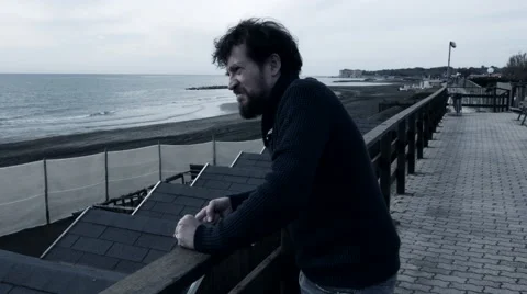 Sad lonely angry man in front of the ocean Stock Footage 58321921