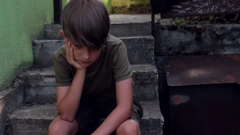 Sad lonely boy alone on the steps. Concept of loneliness, bullying, mental Stock Footage 246964130