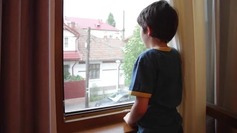 Sad lonely boy child waiting for parents to return home Stock Footage 79596233