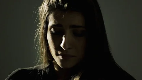 Sad lonely woman almost crying feeling sad in the dark closeup Stock Footage 73995259